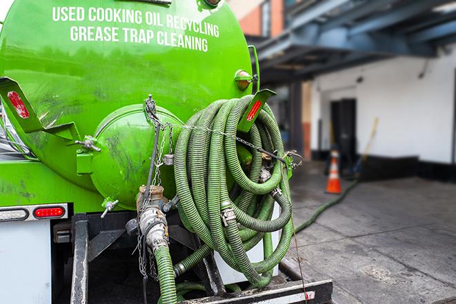 a technician pumping a grease trap in a commercial building in Redmond